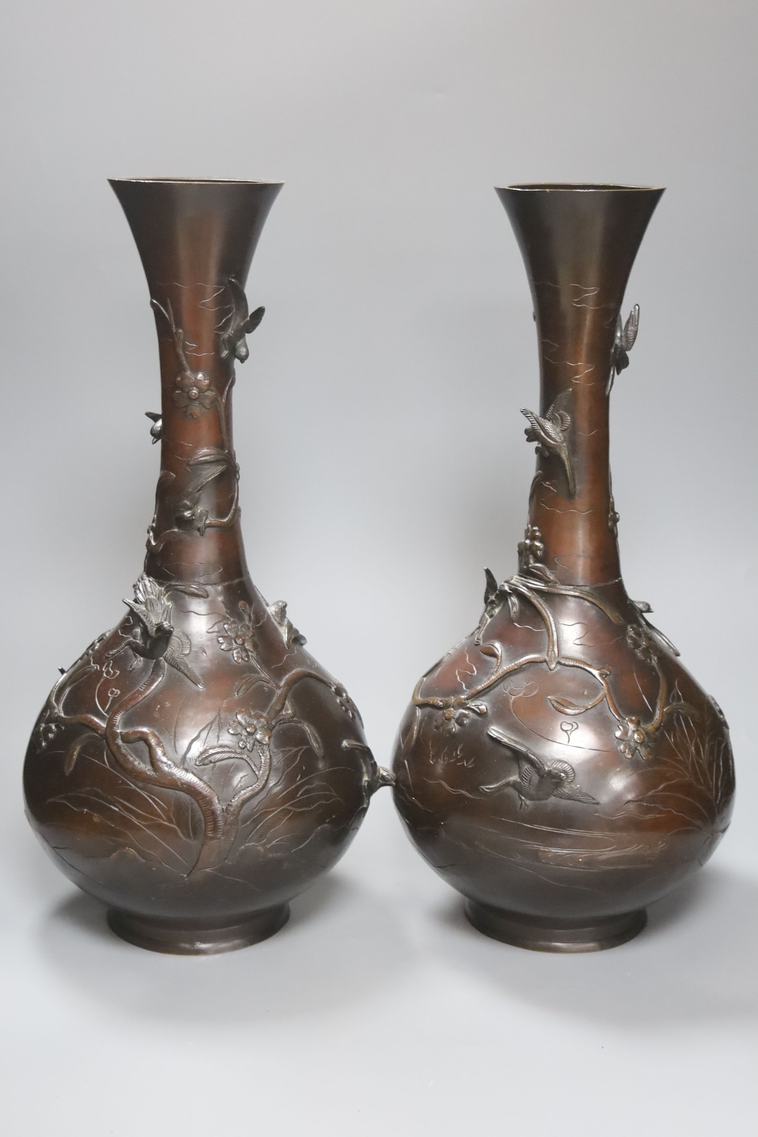 A pair of Japanese Meiji period bronze bottle vases, repaired to neck, height 46cm